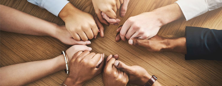 group of people holding hands in prayer